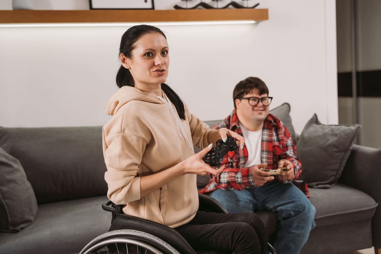 Participant using a wheelchair playing video games with a support worker at home